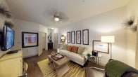 This single-floor residence is thoughtfully designed to maximize functionality and comfort across a well-organized layout. The living room serves as a welcoming central space, featuring warm wood-look flooring, a ceiling fan, and a neutral color palette accented by a series of framed botanical artwork arranged along the main wall. The adjacent dining area benefits from a trio of windows, filling the space with natural light and providing an inviting setting for everyday dining.

The kitchen is outfitted with dark espresso cabinetry, granite countertops, stainless steel appliances, a tile backsplash, and track lighting overhead—offering both style and practicality. Wood-look flooring continues throughout, complementing the rich cabinetry tones.

Both bedrooms are comfortably scaled, carpeted, and feature ceiling fans and windows with blinds that allow for adjustable natural light. The primary bedroom connects to a spacious walk-in closet with wire shelving running along both sides, offering generous storage. The primary bathroom includes dark cabinetry, granite countertops, a large mirror, tile flooring, and a soaking tub with a tiled surround. A dedicated laundry area with side-by-side units adds further convenience to the unit's practical design.