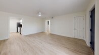 Located at 2690 Drew St in Clearwater, Florida, this single-floor, two-bedroom, two-bathroom residence offers a clean and modern aesthetic throughout. Light wood-style flooring runs seamlessly across every room, complementing the crisp white walls and creating a bright, airy atmosphere.

The living room serves as a welcoming entry point, featuring a bold navy front door, a large window that invites natural light, and direct access to the hallway leading to the rest of the unit. The galley-style kitchen is a standout feature, outfitted with white shaker cabinets, granite countertops, a stainless steel sink, and stainless steel appliances including a refrigerator and electric range.

The spacious primary bedroom offers ample room and includes a double-door closet, while a separate walk-in closet with wire shelving provides generous additional storage. The second bedroom features a window with an outdoor view, filling the room with natural light. Both bathrooms are finished in a clean, minimalist style with tub-shower combinations and brushed gold hardware accents.

A connecting hallway ties all rooms together efficiently, contributing to a well-organized and functional layout ideal for comfortable everyday living in the heart of Clearwater.