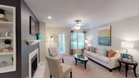 The Camden's 2-bedroom, 2-bathroom residence is thoughtfully laid out across a single floor, offering a functional and comfortable living experience. The living room serves as a welcoming centerpiece, featuring a classic fireplace with a white mantle, neutral carpet flooring, a ceiling fan, and a glass door that opens to an outdoor area, allowing natural light to fill the space.

Adjacent to the living room, a dedicated dining area accommodates a full-sized table with seating for six, finished with chair rail molding along the walls and carpeted flooring. The galley-style kitchen is equipped with white cabinetry, granite-style countertops, wood-look hard surface flooring, and black Whirlpool appliances including a refrigerator, range, and microwave.

Both bedrooms are generously proportioned with plush carpet, natural light from window panels, and ample room for full bedroom furniture sets. Each of the two full bathrooms features a tub-shower combination, wood-look flooring, and white vanity cabinetry with granite-style countertops. A dedicated in-unit laundry area houses a full-sized Whirlpool washer and dryer with overhead shelving, adding everyday convenience to this well-appointed residence.