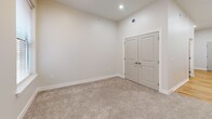 Located at 113 N Ohio Ave, Unit 206, in Sidney, Ohio, this efficiently designed unit offers a well-organized single-floor layout that makes the most of its compact footprint. The open kitchen serves as a centerpiece, featuring crisp white shaker cabinetry extending to the ceiling for ample storage, gray countertops, a stainless steel sink, and a full suite of stainless steel appliances including a refrigerator, range, built-in microwave, and dishwasher. Light hardwood flooring runs throughout the kitchen and main living areas, lending warmth and a clean, contemporary aesthetic. Recessed lighting illuminates the space with a bright, inviting atmosphere. The bedroom area is carpeted in neutral tones, offering comfort underfoot, and includes a set of double doors leading to a closet, providing practical storage. The full bathroom is finished with a white tub and shower surround featuring built-in corner shelving and brushed nickel fixtures, complemented by wood-look flooring for a cohesive design. The unit's neutral color palette, modern hardware, and clean lines throughout create a move-in-ready space with a fresh, contemporary feel.