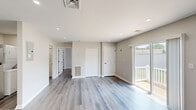 Located at 1932 S Cologne Ave in Mays Landing, NJ, this well-appointed 1-bedroom, 1-bathroom unit offers a clean, modern aesthetic throughout its efficiently designed single-floor layout. Light gray luxury vinyl plank flooring runs continuously through all rooms, complementing the neutral warm-beige walls and crisp white trim for a cohesive, contemporary look.

The open-concept living area is bright and airy, benefiting from recessed lighting and a sliding glass door that leads directly to a private outdoor deck — offering pleasant views of the surrounding community. Multiple closets provide generous storage throughout the unit, alongside a dedicated utility room.

The kitchen is well-equipped with gray shaker-style cabinetry, white quartz countertops, a stainless steel undermount sink with a matte black faucet, and a full suite of stainless steel appliances including a range, over-the-range microwave, and dishwasher.

The spacious bedroom features a large window that allows ample natural light, while the full bathroom includes a gray vanity with a white countertop, a framed mirror with matte black hardware, and a shower-tub combination. The unit's clean finishes and functional layout make it a practical and attractive living space.