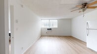 Located at 2707 Portland St in Los Angeles, CA, this single-floor, 1-bedroom, 2-bathroom unit offers a clean and functional layout with a cohesive modern design throughout. Light wood flooring runs continuously across the living areas and bedrooms, lending a bright and airy feel to the space.

The kitchen is well-equipped, featuring dark espresso-toned cabinetry that extends to the upper walls, providing ample storage. A full suite of appliances includes a refrigerator, electric range, and microwave, all set against neutral countertops. A ceiling fan overhead adds airflow to this area.

The generously sized primary bedroom offers notable floor space, a large window that invites natural light, and sliding closet doors for convenient storage. A second, more intimate bedroom also features light wood flooring, a closet, and clean white walls, making it a versatile space for sleeping or working.

Both bathrooms share a consistent design with dark vanity cabinetry, tub-shower combinations enclosed by sliding frosted glass doors, and wood-toned flooring. A hallway connects the rooms efficiently, and two dedicated closet spaces add to the overall storage capacity of the unit. The interior maintains a neutral, minimalist palette throughout, creating a calm and practical living environment.
