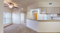 Located in Johnson, Arkansas, this single-floor residence offers a practical and comfortable layout designed for everyday living. The open-concept living and dining area is finished with neutral-toned carpet and features a ceiling fan overhead, creating an airy, relaxed atmosphere. A decorative chandelier accents the dining area, adding a touch of warmth to the space.

The kitchen is positioned centrally and defined by a peninsula-style breakfast bar that separates it from the living area, providing both functional counter space and a casual dining option. Light wood cabinetry lines the upper walls, offering ample storage, while the kitchen is equipped with a coil-burner electric range, a dishwasher, a refrigerator, and a ventilation hood. Countertops are finished in a neutral laminate, complementing the overall color palette.

The bedroom is generously sized with soft carpeting, a ceiling fan, and access to a closet for storage. The bathroom includes a full soaking tub and shower combination with clean white surround walls. Throughout the unit, textured ceilings, arched interior doorways, and consistent neutral tones contribute to a cohesive and understated aesthetic.