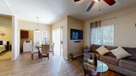 This single-story, 3-bedroom, 2-bathroom residence offers a thoughtfully designed layout that maximizes comfort and functionality. The open-concept living and dining area serves as the heart of the home, featuring warm wood-look flooring, neutral-toned walls, and ceiling fans throughout. The living room accommodates generous seating and is brightened by a window with outdoor views, while the adjacent dining area opens to the outside through a sliding glass door, allowing natural light to flow freely.

The kitchen is well-equipped with rich dark wood cabinetry, granite countertops, stainless steel appliances including a range, microwave, and dishwasher, and a breakfast bar that adds both workspace and casual seating. Wood-look tile flooring ties the kitchen seamlessly into the common areas.

The primary bedroom offers a comfortable retreat with carpeted floors, a ceiling fan, a window for natural light, and direct access to a dedicated walk-in closet with built-in shelving. The additional bedrooms are carpeted and well-proportioned, each with closet access. The bathrooms are clean and functional, with one featuring a full soaking tub and shower combination with wood-look flooring. Throughout the home, a consistent warm color palette and ceiling fans in each room contribute to a cohesive, comfortable ambiance.