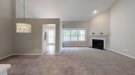 Located at 512 Coventry Ln in Glen Mills, PA, this two-story home offers a well-organized layout across both levels. The main floor centers around a generously sized living room with plush carpeting, soaring vaulted ceilings, and a classic fireplace with a white mantel. Large windows frame views of the surrounding greenery, filling the space with natural light. An arched opening connects the living area to a bright kitchen equipped with white shaker-style cabinetry, granite-look countertops, a stainless steel sink, and stainless steel appliances including a dishwasher and microwave. Wood-look flooring adds a clean, modern contrast in the kitchen. A compact half bath with a mirrored medicine cabinet and white vanity is also found on this level. A white-railed staircase with carpeted treads leads to the upper floor, where multiple carpeted bedrooms await, each featuring natural light from well-placed windows. Vaulted ceilings elevate the sense of space in the upper-level rooms. A full bath on this level features warm tile surround and a tub-shower combination with wood-look flooring. Hallways with closet storage and recessed lighting provide practical connectivity throughout. The overall palette of neutral tones and clean finishes creates a bright, move-in-ready atmosphere.