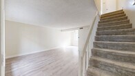 Located in Santa Clarita, CA, this two-story, 2-bedroom, 2-bathroom home offers a clean, neutral aesthetic with thoughtful layout across two well-proportioned floors. The main level welcomes you with light wood-style flooring that flows through the open living and dining areas, filling the space with a bright, airy feel. Natural light pours in through large windows, enhancing the home's crisp, white walls and textured ceilings. A carpeted staircase with white-painted railings connects the two levels. The kitchen features white cabinetry, ample counter space, and a full suite of stainless steel appliances including a range, microwave, and refrigerator, complemented by light wood flooring and a skylight overhead. Upstairs, both bedrooms are carpeted and generously sized, each equipped with sliding-door closets for practical storage. The primary bedroom offers serene outdoor views through a large window. The bathrooms are finished in light, neutral tones, with the upper bath showcasing a white vanity, wood-look tile flooring, and a frosted privacy window. With four closets distributed throughout, the home provides ample storage. The consistent use of soft neutrals and natural light throughout creates a calm, welcoming atmosphere.