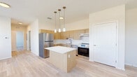 Located at 800 Everett Way in Perry, FL, this single-story one-bedroom, one-bathroom unit offers a thoughtfully designed open-concept layout. Light wood-tone flooring runs throughout, creating a clean and cohesive aesthetic across all areas of the home.

The living, dining, and kitchen areas flow seamlessly together in a bright, open space. Large windows along the exterior wall invite generous natural light and offer outdoor views, while a ceiling fan provides year-round comfort. The kitchen is a standout feature, equipped with warm wood-toned cabinetry, stainless steel appliances including a refrigerator and range, a tile backsplash, and a central island with a white countertop and pendant lighting overhead — ideal for both meal prep and casual dining.

The bedroom is a well-sized private retreat featuring two windows, a ceiling fan, and two closets for ample storage. A hallway connects the main living areas to the bedroom and bathroom, which includes a wood-toned vanity with a white countertop, a wall mirror with vanity lighting, and a walk-in shower with a linear drain. A dedicated laundry area adds everyday convenience. The unit's modern finishes and efficient layout make it a practical and comfortable home.