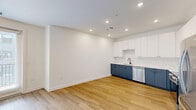 This well-appointed one-bedroom, one-bathroom apartment at 900 N Allen Ave in Richmond, Virginia offers a thoughtfully designed layout across a single floor. The open-concept living and kitchen area is bright and airy, featuring warm light wood-tone flooring and recessed lighting that creates a clean, modern atmosphere. The kitchen is a standout feature, equipped with stainless steel appliances including a French door refrigerator, electric range, over-the-range microwave, and dishwasher. Two-toned cabinetry — crisp white uppers paired with slate-blue lower cabinets — adds a contemporary, stylish contrast against white quartz countertops and a subway tile backsplash. The bedroom is comfortably sized, enhanced by a ceiling fan, two windows that bring in natural light and views of the surrounding neighborhood, and direct access to a walk-in closet outfitted with wire shelving for organized storage. The full bathroom is finished in a clean, neutral palette with large-format tile flooring, a slate-blue vanity with white countertop, a framed mirror, and a full tub-shower combination. Additional conveniences include a dedicated in-unit laundry area and a private balcony, rounding out a functional and modern living space in the heart of Richmond.
