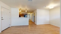 This single-floor residence offers a well-designed, functional layout that balances open communal spaces with private retreats. The living area features warm light hardwood-style flooring and clean white walls, creating a bright and welcoming atmosphere. A pass-through breakfast bar connects the living space to the kitchen, which is finished with rich dark cabinetry, light countertops, and black appliances including a refrigerator and range. The galley-style kitchen provides generous counter and cabinet space along both walls, complemented by a double sink and pendant lighting overhead.

The bedrooms are finished with plush neutral carpeting and receive natural light through large windows with blinds. At least one bedroom includes access to a walk-in closet with built-in shelving, offering practical storage solutions. One room features a glass-panel door leading to an outdoor area, providing a pleasant connection to the exterior.

The bathrooms maintain a consistent design aesthetic, featuring light hardwood-style flooring, dark vanity cabinetry with light countertops, and full tub-shower combinations. Accessibility grab bars are present in one of the bathrooms. Throughout the unit, the neutral color palette, clean finishes, and thoughtful layout come together to create a comfortable and cohesive living environment.