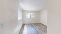 Located at 6502 E Golf Links Rd in Tucson, Arizona, this efficient one-bedroom, one-bathroom unit offers a well-organized single-floor layout ideal for comfortable everyday living. Throughout the space, light wood-style flooring adds warmth and continuity, complementing the crisp white walls and textured ceilings found in every room.

The bedroom is a generously proportioned retreat, featuring a large window dressed with vertical blinds that invites natural light and provides views of the surrounding greenery. A built-in closet with a coat rack offers convenient storage and organization. The clean, neutral palette makes the room feel open and adaptable.

The kitchen is a functional standout, showcasing rich, warm-toned wood cabinetry that wraps around the room in an L-shaped configuration. White countertops provide a clean contrast, while appliances including a dishwasher and electric range offer full cooking capability. A peninsula counter adds additional prep space and a sense of definition within the layout.

The bathroom is neatly appointed with a tub-shower combination, clean white tile surround, and matching fixtures, continuing the home's consistent and tidy aesthetic. Wood-style flooring carries through here as well, tying the space together seamlessly. Overall, this unit offers a practical and comfortable living environment in a well-connected Tucson location.
