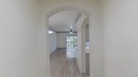 This newly renovated single-story home boasts a contemporary design with an emphasis on open spaces and natural light. The main living area features arched entryways, sleek light-colored flooring, and a balcony overlooking lush vegetation. The kitchen is equipped with stainless steel appliances and white cabinetry, complemented by a subway tile backsplash. Bedrooms are spacious with large windows and ceiling fans. Bathrooms showcase modern fixtures, including double vanities with ample storage. The property's layout promotes a seamless flow between rooms, creating an inviting and functional living environment.