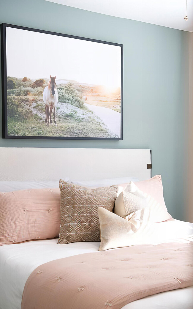 Spacious bedroom with tall ceilings and light green accent wall - Novel Cary