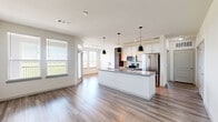 Located in Baytown, TX, this thoughtfully designed single-story residence offers three bedrooms, three bathrooms, and a well-organized floor plan that maximizes comfort and functionality. Light wood-look flooring runs through the main living areas, creating a clean, contemporary aesthetic that flows seamlessly from room to room.

The open-concept kitchen is a standout feature, anchored by a granite-topped island with a double undermount sink and stylish pendant lighting. White upper cabinetry contrasts elegantly with dark wood lower cabinets, while stainless steel appliances — including a French door refrigerator, electric range, and over-the-range microwave — complete the modern look. The kitchen connects naturally to the dining and living areas, which are bathed in natural light from multiple windows offering views of the surrounding greenery.

The bedrooms offer a mix of soft carpeting and wood-look flooring. Several rooms feature large windows with outdoor views, and the primary bedroom includes a ceiling fan for added comfort. Each bedroom is supported by its own closet, and three full bathrooms serve the home — one showcasing a granite vanity with gold hardware and a tiled soaking tub surround. A dedicated laundry space with a full-size washer and dryer rounds out this well-appointed home.