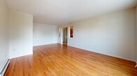 Located at 554 Connecticut Ave in Norwalk, CT, this single-floor residence offers three bedrooms, two bathrooms, a living room, and a kitchen within a well-organized layout. Warm hardwood flooring flows throughout the main living areas and bedrooms, lending a cohesive and inviting feel to the home. The spacious living room is bright and open, connecting naturally to the rest of the floor plan. A sliding glass door leads out to a private deck overlooking lush, mature trees, bringing natural light and serene outdoor views into the space. The generously sized primary bedroom features dual closets with bi-fold doors, offering ample storage, and includes a sliding door with direct deck access. Additional bedrooms are well-proportioned, each fitted with large windows that welcome natural light and views of the surrounding greenery. Baseboard heating is present throughout. The kitchen is equipped with warm wood cabinetry, granite countertops, stainless steel appliances including a range, microwave, and refrigerator, and durable tile flooring. The bathrooms are clean and functional; the full bath features marble-style tile flooring, a tub-shower combination, and a vanity with a white countertop. The overall ambiance is comfortable and practical, suited for everyday living.