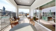 Located at 1551 Beltmill Pkwy in Saginaw, Texas, this outdoor BBQ and amenity area is thoughtfully designed for community gathering and al fresco entertaining. The space is anchored by a covered patio pavilion clad in white shiplap siding with a dark-accented tray ceiling, offering a comfortable shaded retreat furnished with wicker and rattan lounge seating, plush cushioned sofas, a sculptural coffee table, and additional ottomans. Large sliding glass doors connect the covered area to adjacent interior spaces, allowing for seamless indoor-outdoor flow and an abundance of natural light. The open-air patio extends outward with light stone tile flooring throughout, providing generous space for outdoor dining tables paired with shaded umbrellas and bar-height seating along an exterior counter. A standout feature of the space is the built-in outdoor kitchen, equipped with stone-clad grilling stations and multiple stainless steel grills, ideal for community barbecues. Black iron fencing defines the perimeter, offering both security and clear sightlines to the surrounding pool area and neighborhood beyond. The overall ambiance is clean, modern, and welcoming, blending farmhouse-inspired architectural elements with practical, community-focused outdoor amenities.