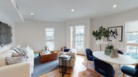 Located on W Third Street in the heart of Los Angeles, this single-story unit presents a clean, contemporary design throughout. The open-concept living and dining area serves as the centerpiece of the space, featuring warm hardwood flooring, crisp white walls, and recessed lighting that enhance the bright, airy atmosphere. A set of French doors floods the room with natural light and opens to a private balcony with neighborhood views, complemented by an additional side window that further brightens the space.

The kitchen is outfitted with high-gloss white cabinetry, quartz countertops, a classic white subway tile backsplash, and stainless steel appliances, including a range, over-the-range microwave, and refrigerator — delivering a polished, functional cooking space.

The unit includes two well-proportioned bedrooms, each finished with hardwood floors and ample closet storage. One bedroom features a large window with neighborhood views and generous natural light. The two bathrooms continue the modern aesthetic, showcasing white penny tile flooring, subway tile surrounds, a glass-enclosed tub-shower combination, and a walk-in shower with brushed nickel fixtures. An in-unit washer and dryer add everyday convenience to this thoughtfully designed Los Angeles residence.