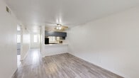Located at 1525 Bridge St in Yuba City, California, this two-bedroom, one-bathroom single-floor residence offers a practical and well-appointed layout. Light-toned wood-look flooring flows through the main living areas, creating a clean, cohesive aesthetic throughout. The combined living and dining area is bright and open, anchored by a ceiling fan and filled with natural light. A pass-through kitchen peninsula with white quartz-style countertops connects seamlessly to the living space, while the kitchen itself features gray cabinetry, black appliances including a range and refrigerator, and ample storage. A hallway leads to the two bedrooms, both finished with plush carpeting and windows fitted with blinds for natural light and privacy. The primary bedroom offers a comfortable footprint with direct closet access. Three closets throughout provide generous storage options. The full bathroom is finished with wood-look flooring, a gray vanity with a large mirror, and clean white fixtures. A dedicated laundry area adds everyday convenience. Sliding glass doors in the living area open to a private patio, offering a pleasant outdoor retreat. The entrance and hallway complete this efficiently designed, move-in-ready residence.