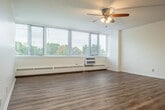 Located at 4828 Regent St in Madison, WI, this one-bedroom, one-bathroom residence offers a well-organized, efficiently designed single-floor layout. The open living and dining area is a standout feature, bathed in natural light through a wide bank of windows that frame lush, tree-lined outdoor views. Hardwood-style flooring runs throughout the main living spaces, complemented by ceiling fans that add both function and character. The kitchen is thoughtfully appointed with rich wood cabinetry, granite-look countertops, a dishwasher, electric range, and a stainless steel refrigerator — all set atop matching hardwood-style flooring for a cohesive look. The bedroom offers plush carpeting underfoot, a ceiling fan, a large window with outdoor views, and generous built-in closet space with louvered bi-fold doors. Multiple additional closets throughout the unit provide excellent storage capacity. The bathroom features a full tub and shower combination with white tile surround and stainless steel grab bars for added accessibility. Baseboard heating runs along the exterior walls throughout, ensuring comfort year-round. The entrance opens conveniently into the main living area, creating a seamless and functional flow throughout the home.