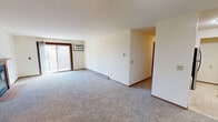 This 2-bedroom, 1-bathroom unit in Madison, Wisconsin offers a thoughtfully arranged single-floor layout designed for comfortable everyday living. The carpeted living room is generously sized, featuring a ceiling fan, baseboard heating, and a sliding glass door that opens to a private balcony with outdoor views — an ideal spot for natural light and fresh air. A wall-mounted air conditioning unit ensures year-round comfort.

The galley-style kitchen is well-appointed with warm oak cabinetry, dark granite countertops, a double stainless steel sink, and black appliances including a refrigerator and range. Light tile flooring and ample upper and lower cabinet storage make this an efficient and functional cooking space.

Both bedrooms are carpeted and bright, each benefiting from natural light through windows with wood-trimmed frames. The primary bedroom is comfortably sized and includes a walk-in closet with dual hanging rods and shelving. The second bedroom features a built-in closet with bifold doors and an organized shelving system, offering generous storage.

The full bathroom is clean and straightforward, with a tiled tub-shower combination in white. Throughout the unit, consistent warm wood trim, neutral wall tones, and plush carpeting create a cohesive and inviting atmosphere.