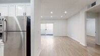Located at 10656 N Moorpark St in the desirable Toluca Lake neighborhood of Los Angeles, this single-story unit has been thoughtfully updated throughout with a clean, modern aesthetic. Light wood-style flooring runs continuously across all living areas, bedrooms, and bathrooms, creating a cohesive and bright atmosphere complemented by crisp white walls and recessed lighting.

The open living area is generously proportioned, featuring a sliding glass door that invites natural light and provides access to an outdoor area. The layout flows naturally into the kitchen, which is equipped with white shaker cabinetry, dark granite countertops, stainless steel appliances including a refrigerator, dishwasher, and range, and a single-basin sink beneath a window with horizontal blinds.

Multiple bedrooms offer well-sized footprints, each featuring recessed lighting, window blinds for privacy, and access to closets with built-in shelving systems. Two full bathrooms serve the unit; one includes a single vanity with a marble-style countertop and tub-shower combination with matte black fixtures, while the second features a dual-sink vanity with dual round mirrors and matching matte black hardware, also with a tub-shower. The overall design is clean, minimal, and move-in ready.