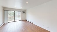 Located at 840 Cherry Valley Road in Vernon Hills, IL, this one-bedroom, one-bathroom unit offers a well-organized, single-floor layout designed for comfortable everyday living. The combined living and dining area is the heart of the home, showcasing warm hardwood-style flooring, crisp white walls, and recessed lighting. A wall-mounted A/C unit and baseboard heating ensure year-round comfort. Sliding glass doors open directly onto a private balcony, filling the space with natural light and providing pleasant outdoor views. The kitchen features granite-style countertops, a tile backsplash, a gas range, and a stainless steel sink, seamlessly connected to the living area via a pass-through counter. The bedroom is carpeted for warmth and comfort, outfitted with a ceiling fan and natural light from a window. It also boasts generous closet storage with two full-width sliding-door closets. The bathroom is finished with tile flooring, a granite-topped wood vanity with mirror, and a full tub/shower combination. A hallway connects the main spaces, with additional closets providing ample storage throughout. The unit's clean, neutral palette and functional layout make it a versatile and inviting living space.