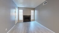 Located at 7795 McCallum Blvd in Dallas, TX, this one-bedroom, one-bathroom unit is thoughtfully laid out across a single floor. Light wood-style flooring runs throughout, complemented by neutral gray walls and white trim, creating a clean and cohesive aesthetic. Textured ceilings add a classic character to each room.

The combined living, dining, and kitchen area forms the heart of the unit. The living room features a tile-surround fireplace flanked by two windows fitted with blinds, allowing natural light to fill the space. The kitchen is defined by a raised granite-topped breakfast bar, white cabinetry, and black appliances including a refrigerator, electric range, and over-the-range microwave. An adjacent pantry provides additional storage.

The bedroom is a comfortable, well-proportioned room with a ceiling fan, a large window with vertical blinds, and access to two closets for ample storage. The full bathroom includes a tub-shower combination with tile surround, a granite-topped vanity, and clean white finishes throughout.

Additional highlights include a dedicated laundry area and convenient HVAC venting throughout. The layout makes efficient use of every square foot, making this unit a practical and functional space in north Dallas.