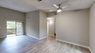 Located in Chamblee, Georgia, this single-floor residence at Oakwood Village offers a clean, modern aesthetic throughout. The open living area is finished with light hardwood-style flooring, neutral gray walls, and a textured ceiling with a ceiling fan, creating a comfortable and airy atmosphere. Sliding glass doors lead directly to a private balcony overlooking a lush, tree-lined backdrop, bringing natural light and serene outdoor views into the main living space.

The kitchen has been thoughtfully updated with white shaker-style cabinetry, granite countertops, and a full suite of stainless steel appliances, including a range, microwave, dishwasher, and refrigerator. Light tile flooring and a window above the sink further brighten the space.

The bedrooms continue the consistent flooring theme and are finished with the same neutral palette, offering a calm and versatile setting. One bedroom features a large window framing views of surrounding greenery, while another connects conveniently to a bathroom. The bathroom includes a full tub-and-shower combination with clean white surrounds and marble-style tile accents.

The private balcony, accessible from the living area, provides a peaceful outdoor retreat surrounded by mature trees, completing this well-appointed Chamblee residence.