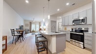 Located at 2272 Parkstone Dr in Indian Land, SC, this single-floor, 3-bedroom, 2-bathroom residence offers a thoughtfully designed open-concept layout with modern finishes throughout. Light hardwood-style flooring flows seamlessly across the entire home, creating a cohesive and airy atmosphere.

The kitchen is a standout feature, boasting gray shaker-style cabinetry, granite countertops, a white subway tile backsplash, and a full suite of stainless steel appliances. A central island with pendant lighting and bar seating makes it ideal for both cooking and entertaining. The kitchen opens directly into the living room, which is bright and welcoming with large French doors that invite natural light and outdoor views.

The primary bedroom is a comfortable retreat, featuring vaulted ceilings, a ceiling fan, and a walk-in closet outfitted with wire shelving. The primary bathroom includes a dual-sink vanity with granite countertops, white cabinetry, and ample natural light from dual windows. The secondary bathroom mirrors the same clean aesthetic, featuring a white vanity with granite countertops and a full tub-shower combination. The additional bedrooms are well-sized and versatile. Throughout the home, neutral tones and consistent finishes create a polished, move-in-ready environment.