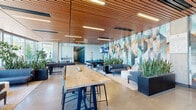 Located at 11690 San Pablo Ave in El Cerrito, California, this contemporary amenity lounge offers a thoughtfully designed, single-floor space that blends recreation, relaxation, and social gathering in a cohesive environment. The interior is anchored by a striking geometric mural wall in teal, gold, and gray tones, serving as both a focal point and a backdrop for multiple activity zones throughout the space.

The lounge features polished concrete floors and a warm wood-slat ceiling that runs the length of the room, lending an organic texture that balances the modern finishes. Recessed linear lighting keeps the space bright and welcoming. A full-size pool table with a bold blue felt surface sits beneath a wall-mounted flat-screen TV, creating a dedicated game and entertainment zone complete with cue storage.

Adjacent to the game area, a comfortable lounge seating arrangement — consisting of gray sofas, accent chairs, and a round ottoman — provides a relaxed setting for conversation or unwinding. Lush potted snake plants and tropical greenery are distributed throughout, adding life and vibrancy to the space.

A long communal high-top table with bar-height seating offers a collaborative workspace or casual dining area. Toward the perimeter, floor-to-ceiling glass windows flood a cozy bistro-style nook with abundant natural light and frame views of the surrounding neighborhood and landscaping.