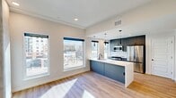 This contemporary 590 square foot apartment in Denver showcases a thoughtful design that maximizes space and light. The open-concept layout seamlessly integrates the living area and kitchen, creating a sense of spaciousness. Large windows flood the space with natural light and offer urban views, enhancing the apartment's modern aesthetic.

The kitchen is a standout feature, boasting sleek gray cabinetry, stainless steel appliances, and a generous island with a built-in sink. Pendant lighting adds a touch of sophistication, while the white subway tile backsplash complements the overall color scheme.

The 130 square foot bedroom provides a cozy retreat, complete with a ceiling fan and ample closet space. The bathroom continues the modern theme with a floating vanity, large mirror, and contemporary fixtures.

Throughout the apartment, light wood flooring adds warmth and continuity. Recessed lighting and clean lines contribute to the space's minimalist appeal. The apartment's single floor layout and efficient design make it an ideal urban dwelling for those seeking a stylish and low-maintenance living space in the heart of Denver.