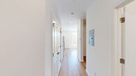 Located at 268 Market St in South Burlington, Vermont, this efficiently designed single-floor unit offers a clean, modern aesthetic throughout. Light wood-style flooring runs continuously across the open layout, lending warmth and visual continuity to the space.

The kitchen is well-appointed with crisp white shaker-style cabinetry extending to the ceiling, dark granite-style countertops, and a full suite of stainless steel appliances including a refrigerator, electric range, built-in microwave, and dishwasher. A large window adjacent to the kitchen floods the cooking and living area with natural light and offers views of the surrounding South Burlington streetscape.

The main living area is bright and open, featuring recessed lighting, a wall-mounted mini-split unit for climate control, and baseboard heating. Large windows frame outdoor views and allow generous daylight to stream in, enhancing the airy feel of the space.

The bathroom is clean and functional, finished with the same wood-style flooring and bright white walls. It features a walk-in shower unit with built-in shelving and a grab bar, recessed overhead lighting, and a toilet, all presented in a minimalist, accessible design.

Overall, this unit offers a fresh, modern living environment with thoughtful finishes and practical amenities in a convenient South Burlington location.