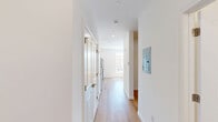Located at 268 Market St in South Burlington, Vermont, this efficiently designed single-floor unit offers a clean, modern aesthetic throughout. Light wood-style flooring runs continuously across the open layout, lending warmth and visual continuity to the space.

The kitchen is well-appointed with crisp white shaker-style cabinetry extending to the ceiling, dark granite-style countertops, and a full suite of stainless steel appliances including a refrigerator, electric range, built-in microwave, and dishwasher. A large window adjacent to the kitchen floods the cooking and living area with natural light and offers views of the surrounding South Burlington streetscape.

The main living area is bright and open, featuring recessed lighting, a wall-mounted mini-split unit for climate control, and baseboard heating. Large windows frame outdoor views and allow generous daylight to stream in, enhancing the airy feel of the space.

The bathroom is clean and functional, finished with the same wood-style flooring and bright white walls. It features a walk-in shower unit with built-in shelving and a grab bar, recessed overhead lighting, and a toilet, all presented in a minimalist, accessible design.

Overall, this unit offers a fresh, modern living environment with thoughtful finishes and practical amenities in a convenient South Burlington location.
