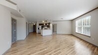 Located at 144 Ponce de Leon Ave NE in Atlanta's vibrant Midtown neighborhood, this well-appointed single-floor residence offers a thoughtfully designed open-concept layout that seamlessly connects the living, dining, and kitchen areas. Light hardwood flooring flows throughout the main living spaces, complemented by neutral-toned walls that create a bright, welcoming atmosphere. Large windows and glass doors flood the living area with natural light while offering views of the surrounding cityscape.

The kitchen is a standout feature, outfitted with gray shaker-style cabinetry, granite countertops, a classic subway tile backsplash, and a full suite of stainless steel appliances, including a French door refrigerator, range, microwave, and dishwasher. A peninsula with pendant lighting provides additional prep space and a casual dining option.

The bathroom is well-proportioned, featuring granite countertops, a dual-sink vanity with white cabinetry, wood-look tile flooring, and both a soaking tub and a separate shower. The bedroom includes a generously sized walk-in closet with wire shelving for ample storage. A dedicated in-unit laundry area with a full-size washer and dryer adds everyday convenience. Additional closet space with wire rack shelving is also present throughout the unit.