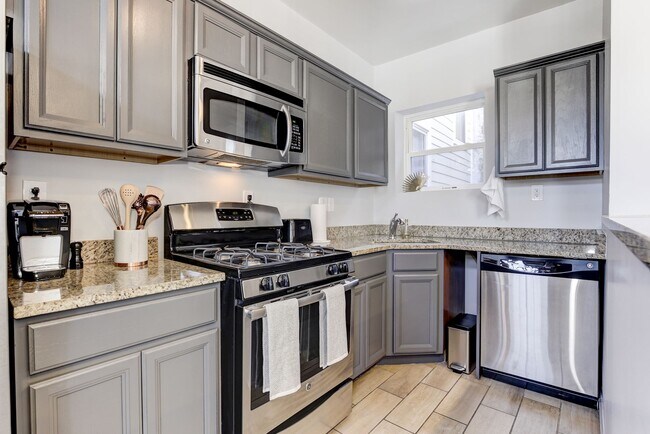 Cocina renovada con encimeras de granito y electrodomésticos de acero inoxidable. - 1719 4th St NW