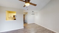 Located at 2500 W 5th St in Greenville, North Carolina, this single-floor residence offers a well-designed layout with a range of thoughtful details throughout. The living area greets you with soaring vaulted ceilings, wood-look luxury vinyl plank flooring, and a ceiling fan that enhances the open, airy feel. A large window allows natural light to fill the space, while a bold dark front door adds character to the entryway. The dining area features a stylish pendant light fixture, and a pass-through connects seamlessly to the kitchen. The kitchen is outfitted with white cabinetry, subway tile backsplash, light countertops, a stainless steel sink, and full-size stainless steel appliances, including a refrigerator and dishwasher. The primary bedroom impresses with vaulted ceilings, plush carpeting, a walk-in closet, and direct access to a private outdoor deck with views of surrounding greenery. An en-suite bathroom is conveniently accessible from the bedroom. Additional bedrooms are carpeted and feature windows that bring in natural light. The bathroom includes a full tub and shower combination. Throughout the home, neutral tones and clean finishes create a cohesive and comfortable living environment.