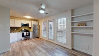 This well-appointed single-floor residence offers a clean, modern aesthetic carried consistently throughout every room. The open-concept living and kitchen area serves as the heart of the space, featuring light-toned laminate wood flooring, a ceiling fan with integrated lighting, and a textured ceiling. Large windows and a glass-panel door flood the living area with natural light and provide views of the outdoors, while built-in wall shelving adds functional display and storage space.

The kitchen is thoughtfully designed with crisp white cabinetry, granite-look countertops, and a striking herringbone-patterned tile backsplash. A full suite of stainless steel appliances — including a refrigerator, electric range, over-the-range microwave, and dishwasher — rounds out the kitchen's modern and practical appeal.

The bedroom is a calm, well-lit retreat with the same laminate wood flooring, a ceiling fan, neutral walls, and a bright window with blinds that welcome natural light. A closet provides ample storage.

The bathroom features a clean, minimalist design with light wood-tone flooring, white fixtures, and a functional layout. Throughout the entire residence, the consistent use of neutral tones, natural light, and modern finishes creates a cohesive and inviting atmosphere.