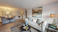 This single-floor residence in Derby offers a thoughtfully organized layout with distinct living, dining, kitchen, and sleeping areas connected by wood-style flooring throughout the main spaces. The living room is a comfortable, well-proportioned area featuring natural light from multiple windows, neutral walls, and a textured ceiling. It flows naturally into the dedicated dining space, which is illuminated by a pendant light fixture and accented by decorative wall art, creating an inviting atmosphere for everyday meals.

The galley-style kitchen is efficiently designed with white shaker cabinetry, light stone-effect countertops, a stainless sink, and black appliances including an electric range with overhead ventilation. Ample upper and lower cabinet storage makes the most of the well-organized corridor layout.

The residence includes two bedrooms, both carpeted and featuring windows that bring in natural light. One bedroom is notably spacious, while the second offers a versatile, open feel. The full bathroom is finished with white cabinetry, a single vanity, tile surround, and a shower-tub combination, maintaining the clean, neutral palette found throughout the home.