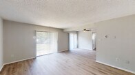 Located at 542 S Broadway in Pennsville, NJ, this single-floor residence offers a well-organized layout with thoughtfully updated interiors. The open living area is finished with light wood-look flooring and features a ceiling fan overhead, while large sliding glass doors with vertical blinds allow generous natural light to fill the space and provide outdoor views. The layout flows seamlessly into a dining and entry area, also finished in the same light flooring for a cohesive look throughout the common spaces. The galley-style kitchen is outfitted with dark gray shaker cabinets, marble-look countertops, a double-basin sink, and black appliances including a range and refrigerator, offering ample storage and prep space. Bedroom spaces feature plush carpeting, large windows with outdoor views, and closet access, providing a quiet and comfortable retreat. The bathroom includes a tiled tub-and-shower combination with classic white subway tile surround, light tile flooring, and a vanity with storage. Neutral gray tones, textured ceilings, and clean white trim are consistent throughout, lending the space a fresh and move-in-ready appeal. Overall, the residence presents a practical and updated living environment in a convenient Pennsville location.