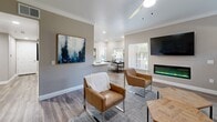 Located at 10270 E Taron Dr in Elk Grove, CA, this single-story 2-bedroom, 3-bathroom home offers a thoughtfully designed layout with modern finishes throughout. The open-concept living area is a standout, featuring wood-look flooring, crown molding, recessed lighting, and a sleek wall-mounted electric fireplace flanked by windows that invite natural light. The kitchen is outfitted with crisp white shaker cabinets, a subway tile backsplash, stainless steel appliances including a refrigerator, range, microwave, and dishwasher, and durable wood-look flooring. The primary bedroom offers a comfortable retreat with plush carpeting, a ceiling fan, and access to natural light through a window. A mirrored sliding closet door adds a sense of depth to the secondary bedroom. The three bathrooms include units with tub-shower combinations — one featuring a soaking tub with chrome fixtures and a built-in caddy, and another with a classic tub and shower curtain setup. Neutral warm-gray tones carry throughout the home, creating a cohesive and calming ambiance well-suited for everyday living.
