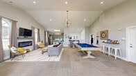 Located at 33451 Mackenzie Way in Lewes, Delaware, this single-floor community clubhouse offers a well-appointed, coastal-inspired gathering space designed for both relaxation and recreation. The main area is anchored by soaring vaulted ceilings and an open-concept layout that seamlessly connects the lounge, dining, and game areas. A statement chandelier and recessed lighting illuminate the spacious interior, while neutral-toned carpet and light walls create a bright, inviting atmosphere.

The full kitchen is equipped with stainless steel appliances, rich wood cabinetry, granite countertops, a decorative tile floor, and a vibrant aqua backsplash that ties in the coastal aesthetic. Adjacent to the main gathering area, a billiards table serves as a central entertainment feature, complemented by a high-top bar and cue rack along the wall.

The entry foyer greets visitors with a large arched window, French doors, and a dedicated coffee station, setting a warm and welcoming tone. A separate dining area with arched windows provides a bright, comfortable space for smaller gatherings. A dedicated children's room offers a wall-mounted TV, built-in book ledges, and playful seating, making the space family-friendly. Throughout, coastal décor accents reinforce the relaxed, beachside character of this thoughtfully designed community space.