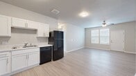 This contemporary 920 square foot apartment offers a thoughtfully designed living space with two bedrooms and one bathroom. The open-concept layout seamlessly integrates the kitchen, living, and dining areas, creating an airy and spacious feel. The kitchen boasts crisp white cabinetry, contrasting black appliances, and ample counter space, perfect for culinary enthusiasts.

The primary bedroom, measuring 210 square feet, provides a generous retreat with plush carpeting and large windows that invite natural light. The second bedroom offers versatility as a guest room or home office. The bathroom features a modern design with a shower/tub combination and sleek fixtures.

Throughout the apartment, you'll find a harmonious blend of materials, including warm wood-look flooring in the main living areas and soft carpeting in the bedrooms. The neutral color palette of whites and light greys creates a canvas for personalization. Practical amenities include a spacious closet with wire shelving for organized storage.

Large windows in each room flood the space with natural light, while ceiling fans ensure comfortable air circulation. The apartment's single-floor layout and thoughtful design make it an ideal home for those seeking modern comfort and convenience in Bettendorf, Iowa.