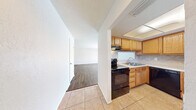 This 860 square foot apartment offers a practical and comfortable living space. The unit features two bedrooms, including a primary bedroom of 150 square feet, and one bathroom. The open-concept design combines the kitchen and living room, creating a spacious feel.

The kitchen is equipped with modern appliances, including a black electric range and refrigerator. Honey-colored wooden cabinets provide ample storage, complemented by light-colored countertops and a tiled backsplash. The adjoining living area features laminate wood flooring and a large sliding glass door, allowing natural light to flood the space.

Both bedrooms are fitted with ceiling fans and windows, ensuring good air circulation and natural lighting. The bathroom showcases a contemporary design with large, neutral-toned tiles and a white bathtub.

A notable feature is the walk-in closet, offering generous storage space with wire shelving. Throughout the apartment, the neutral color palette and laminate flooring create a cohesive, modern aesthetic. The property also includes outdoor space, visible through the sliding glass door in the living area.

This apartment, located in Summit West - 17F - B1, provides a well-designed living space that maximizes functionality within its 860 square feet.