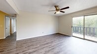 Located at 829 NW 79th Ter in Kansas City, MO, this 2-bedroom, 2-bathroom residence offers a well-organized single-floor layout designed for comfortable everyday living. The open-concept living and dining area is finished with durable wood-look LVP flooring and features a ceiling fan with light kit. A sliding glass door leads directly to a private balcony overlooking lush greenery, filling the space with natural light and outdoor views. The kitchen connects to the living area via a pass-through window, and is equipped with white cabinetry, black appliances including a range and microwave, and a functional countertop workspace. Both bedrooms are carpeted and feature ceiling fans, neutral walls, and natural light from windows. The primary bedroom offers a generous footprint with ample room for furnishings. Each bathroom includes a full tub-and-shower combination with built-in shelving niches and clean white surrounds. One bathroom features additional built-in cabinetry for storage. A dedicated closet completes the layout, providing practical storage solutions. Textured ceilings are consistent throughout the home, adding a classic finishing touch to this well-maintained Kansas City residence.
