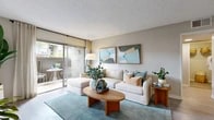 This single-story residence offers a thoughtfully designed floor plan encompassing one bedroom, two bathrooms, a combined living and dining area, a kitchen, and a closet. The living room is bright and welcoming, featuring a textured ceiling, neutral walls, and sliding glass doors that open to a private outdoor patio, filling the space with natural light and providing seamless indoor-outdoor connectivity. Adjacent to the living area, the dining space accommodates an intimate seating arrangement complemented by light wood-toned flooring and contemporary wall art. The galley-style kitchen is well-equipped with dark espresso cabinetry, granite-look countertops, stainless steel appliances including a gas range and refrigerator, and a double sink — offering efficient use of space without sacrificing functionality. A light-filled hallway with wood-look flooring connects the main living areas to the bedroom, which features plush carpet, a window with outdoor views, and a textured ceiling. The two bathrooms are clean and functional, one featuring a full soaking tub and shower combination with light tile flooring. Throughout the residence, a cohesive neutral palette and consistent finishes create a calm, livable ambiance.