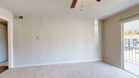 Located at 1834 Wilmington Hwy in Jacksonville, NC, this single-floor, one-bedroom, one-bathroom unit offers a thoughtfully arranged layout across a compact but functional footprint. The living room serves as the heart of the space, featuring soft carpet flooring, a ceiling fan with light fixture, vertical shiplap-style wall paneling, and a sliding glass door that opens to a private balcony with exterior views. A combined dining room and kitchen area flows directly from the living space, showcasing wood-look vinyl flooring, white cabinetry with ample upper and lower storage, light countertops, a stainless steel sink, and white appliances including an electric range and full-size refrigerator. The spacious primary bedroom is carpeted and benefits from a large double window that fills the room with natural light, complemented by neutral walls and a ceiling-mounted light fixture. Three closets throughout the unit provide generous storage options. The full bathroom features a clean, white tiled tub and shower combination with chrome fixtures. A utility room and hallway round out the layout, adding practicality to this efficient and functional single-level home.