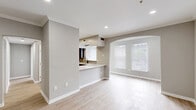 Located at 270 Brandywine Dr in Bear, Delaware, this well-appointed one-bedroom, one-bathroom residence offers a thoughtfully designed single-floor layout with a clean, modern aesthetic throughout. The open-concept living and kitchen area serves as the heart of the home, featuring light wood-style flooring, neutral gray walls, recessed lighting, and crown molding. An elegant arched window floods the living space with natural light, while a graceful arched passageway adds architectural character. The kitchen is fully equipped with dark espresso cabinetry, stainless steel appliances including a range, microwave, refrigerator, and dishwasher, complemented by crisp white quartz countertops and a tile backsplash. A peninsula counter provides additional workspace and casual seating. The spacious bedroom offers plush carpeting, a large window with natural light, and ample room for a full furniture arrangement. The bathroom is finished with a white quartz vanity, dark cabinetry, matte black fixtures, and a full tub-shower combination with tile surround. A dedicated laundry area includes a full-size washer and dryer with built-in wire shelving above. A hallway closet provides additional storage, completing this efficiently designed and stylishly finished home.