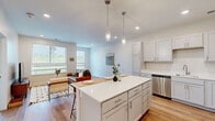 This 680 square foot, single-floor apartment in Goldenrod, Omaha, offers a thoughtfully designed living space. The open-concept layout seamlessly integrates the kitchen, living, and dining areas, maximizing the use of space. The kitchen boasts white cabinetry, stainless steel appliances, and a central island with seating, perfect for casual dining or entertaining.

The living room features large windows that flood the space with natural light, offering views of the surrounding area. Hardwood flooring extends throughout the main living areas, adding warmth and continuity to the design. The bedroom, measuring 160 square feet, includes a ceiling fan and ample closet space. 

The bathroom is well-appointed with a modern vanity, large mirror, and a combination tub-shower. Light neutral colors dominate the walls and surfaces, creating a bright and airy atmosphere throughout. The apartment's efficient design incorporates smart storage solutions, making the most of the available space. Despite its compact size, this apartment offers a comfortable and stylish living environment, ideal for singles or couples seeking a modern urban lifestyle.