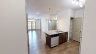 Located at 811 Evolve Way in Knoxville, Tennessee, this two-bedroom, two-bathroom residence offers a well-designed single-floor layout with a comfortable and functional living environment. The open-concept kitchen and living area serves as the heart of the home, featuring rich dark-cabinetry, granite countertops, stainless steel appliances including a refrigerator, range, microwave, and dishwasher, all set atop durable hardwood-style flooring. A central kitchen island with a built-in sink adds both workspace and convenience. The living room extends naturally from the kitchen, bathed in natural light from French doors that open to a private balcony, and is finished with a ceiling fan overhead. Both bedrooms are carpeted for comfort and include ceiling fans and closet storage. The primary bedroom features a spacious closet, while the second bedroom offers a bright window with exterior views. Each bathroom is appointed with dark wood vanities, white countertops, and hardwood-style flooring, maintaining a consistent and cohesive design throughout. Additional storage is provided via dedicated closets. The overall aesthetic is clean and modern, with neutral tones and quality finishes creating a welcoming and move-in-ready atmosphere.