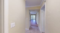 Located at 3200 Tanager Ct in Tallahassee, Florida, this single-floor, 2-bedroom, 2-bathroom residence offers a well-organized layout designed for comfortable everyday living. A central hallway with tile flooring and crown molding connects the main living areas, creating a clean and cohesive flow throughout the home.

The living room serves as the focal point of the space, featuring warm wood-look flooring, crown molding, and a tile-surround fireplace with a white mantel. A large sliding glass door floods the room with natural light and provides views of the surrounding greenery outside. The kitchen is equipped with white cabinetry, ample upper storage, tile flooring, a pantry, and a full suite of appliances including a range, dishwasher, and refrigerator.

Both bedrooms are finished with neutral carpet and feature ceiling fans. The primary bedroom offers a generous footprint with a dedicated closet. Each bathroom is outfitted with tile flooring, white vanity cabinetry, and a tub-shower combination. The overall color palette of warm beige tones throughout creates a consistent and understated ambiance across the entire residence.