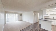Located at 3340 Topaz Ln in Fullerton, CA, this single-floor, 2-bedroom, 3-bathroom residence offers a well-organized and functional layout. The open living area features a combination of plush carpeting and wood-style flooring, with a ceiling fan overhead and a wall-mounted AC unit. Sliding glass doors invite natural light and provide access to an outdoor area. The kitchen is equipped with white cabinetry, dark laminate countertops, a gas range, and an overhead ventilation hood — a ceiling fan in an adjacent nook adds comfort to the dining area. A second kitchen features ample white cabinetry, additional dark countertop workspace, a stainless steel sink, and wood-style flooring, offering excellent utility. Both bedrooms are carpeted and include ceiling fans for comfort. The spacious primary bedroom connects directly to its own en-suite bathroom with white cabinetry and a vanity mirror, while a separate closet provides dedicated storage. The second bedroom features a window with vertical blinds allowing natural light. All three bathrooms include tub-shower combinations with clean white tile surrounds and chrome fixtures. Textured ceilings are consistent throughout, contributing to the residence's clean, neutral aesthetic.